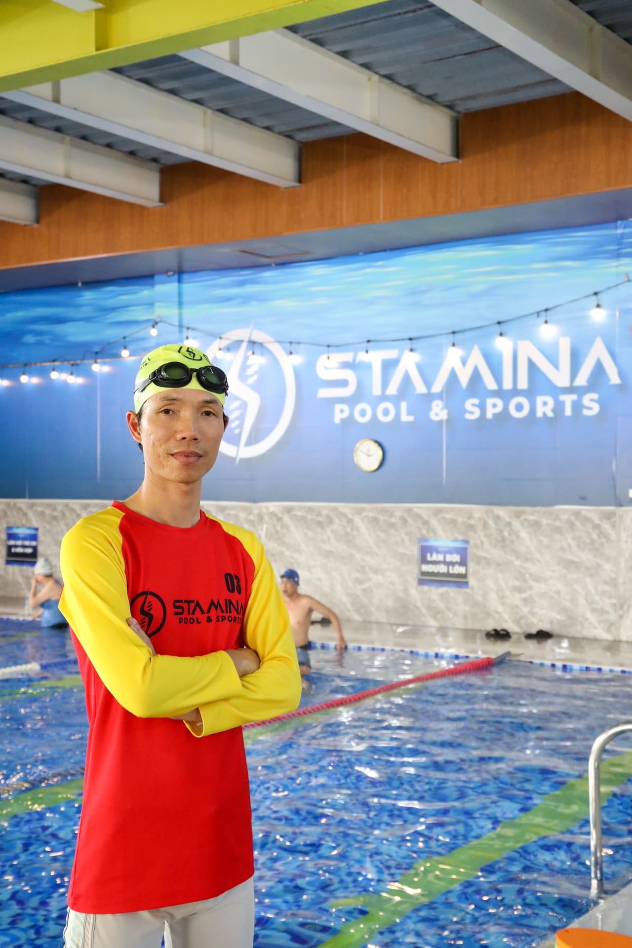 Huấn luyện viên bơi STAMINA tại mép bể bơi